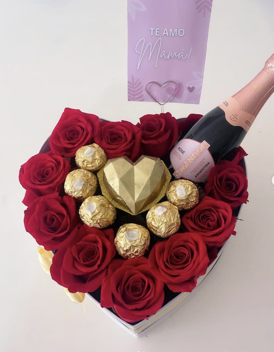Caja en forma de corazón con rosas rojas, bombones y espumante
